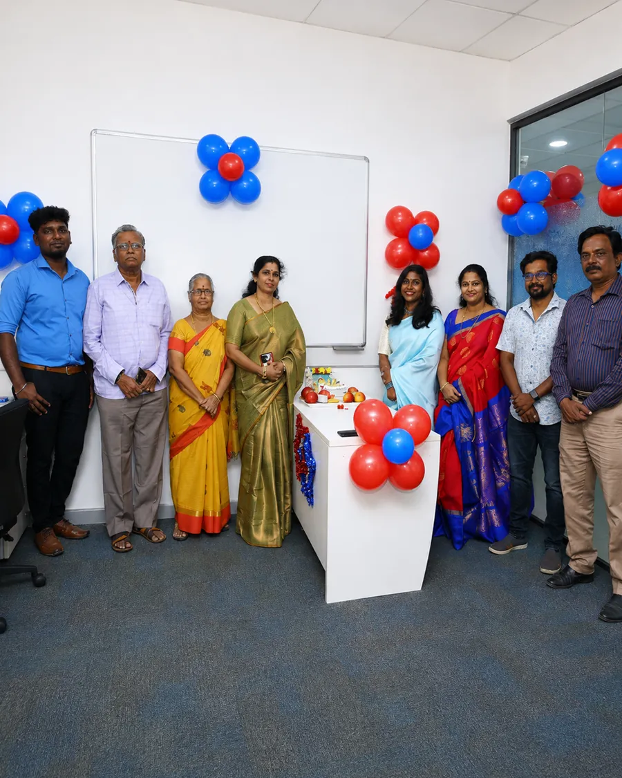 Ascentforce team members posing together in a conference room with balloons.