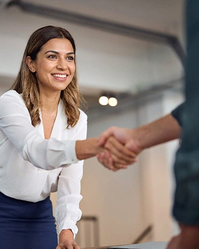 Asentforce professional greeting a candidate during a successful business handshake meeting.