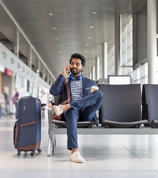 Asentforce traveling employee making a phone call while waiting at airport terminal.