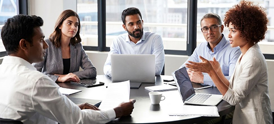 Asentforce business team collaborating during a strategy meeting around an office table.